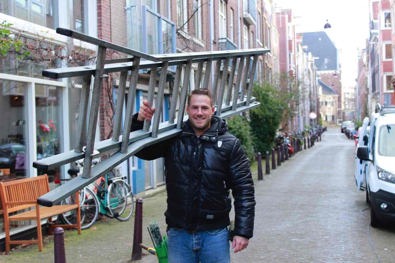 Boy Bolderman, eigenaar, met ladders in een Amsterdamse straat